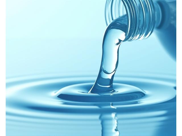 Clear aftershave splash being poured, illustrating its liquid consistency.